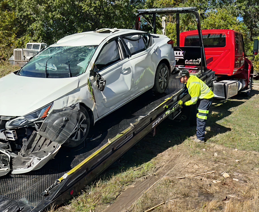 White car on flatbed tow truck.